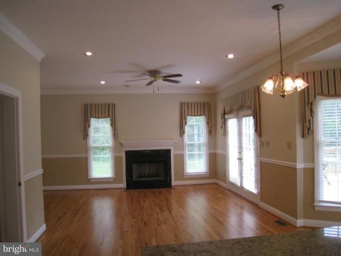 10118 Colvin Run Road Great Falls, VA 22066 - Photo 6 of 26 a view of an empty room with wooden floor fireplace and a window