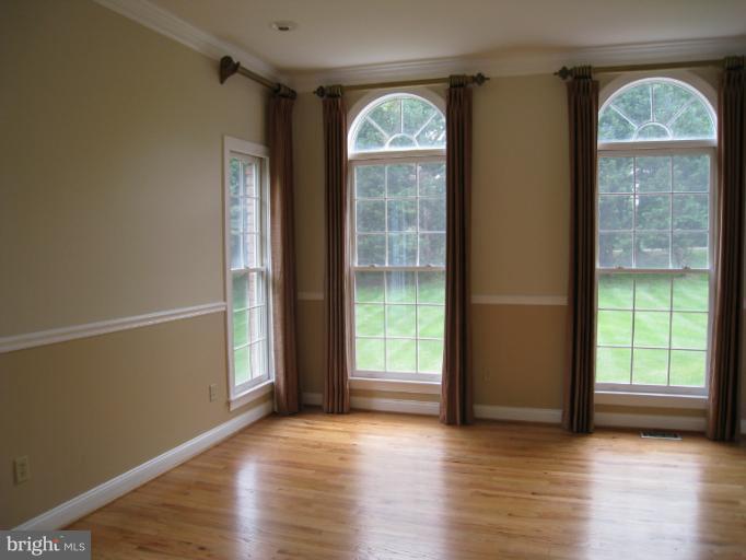 10118 Colvin Run Road Great Falls, VA 22066 - Photo 10 of 26 an empty room with wooden floor and windows