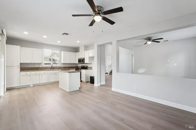 a large kitchen with cabinets and wooden floor