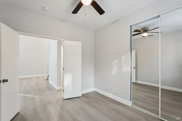 an empty room with ceiling fan and window