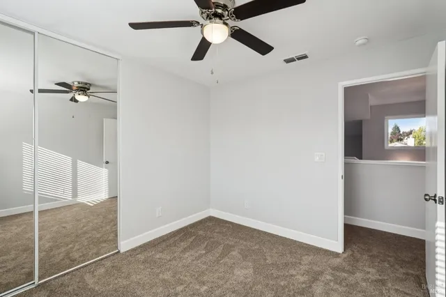 an empty room with a window and a fan