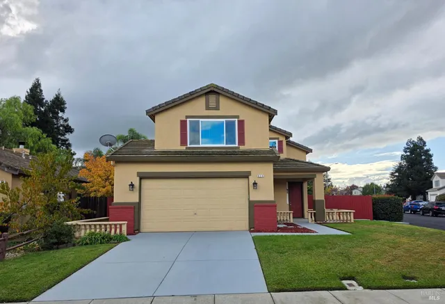 a front view of a house with a yard and garage
