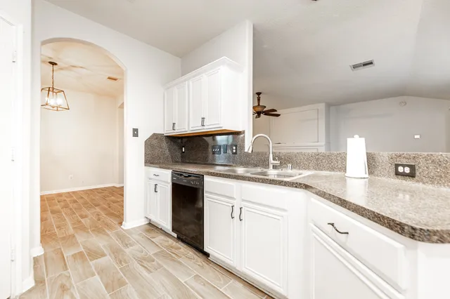 a kitchen with granite countertop a sink stove and refrigerator