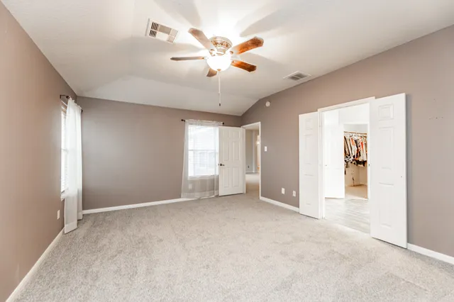 a view of an empty room with a ceiling fan