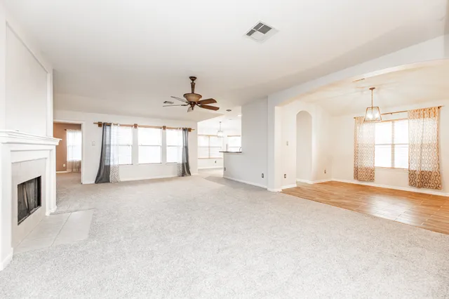 a view of an empty room with a fireplace and a window