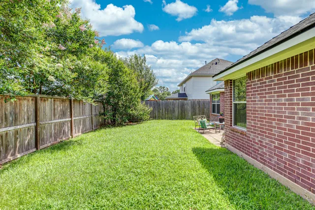 a view of a backyard with table and chairs and wooden fence