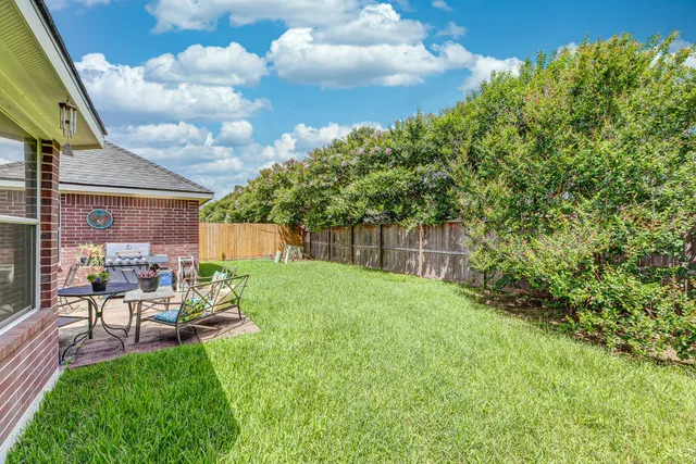 a front view of a house with a yard and a tree
