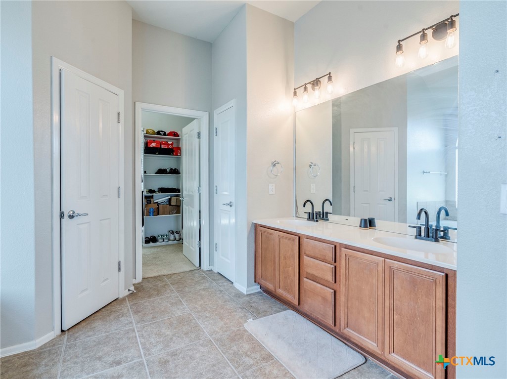 125 Sweet Gum Drive Kyle, TX 78640 - Photo 19 of 31 a spacious bathroom with double vanity and mirrors
