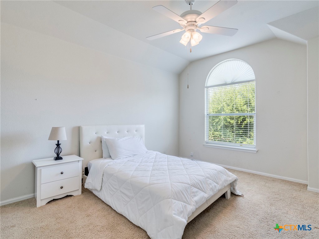 125 Sweet Gum Drive Kyle, TX 78640 - Photo 21 of 31 a bedroom with a bed and a chandelier fan