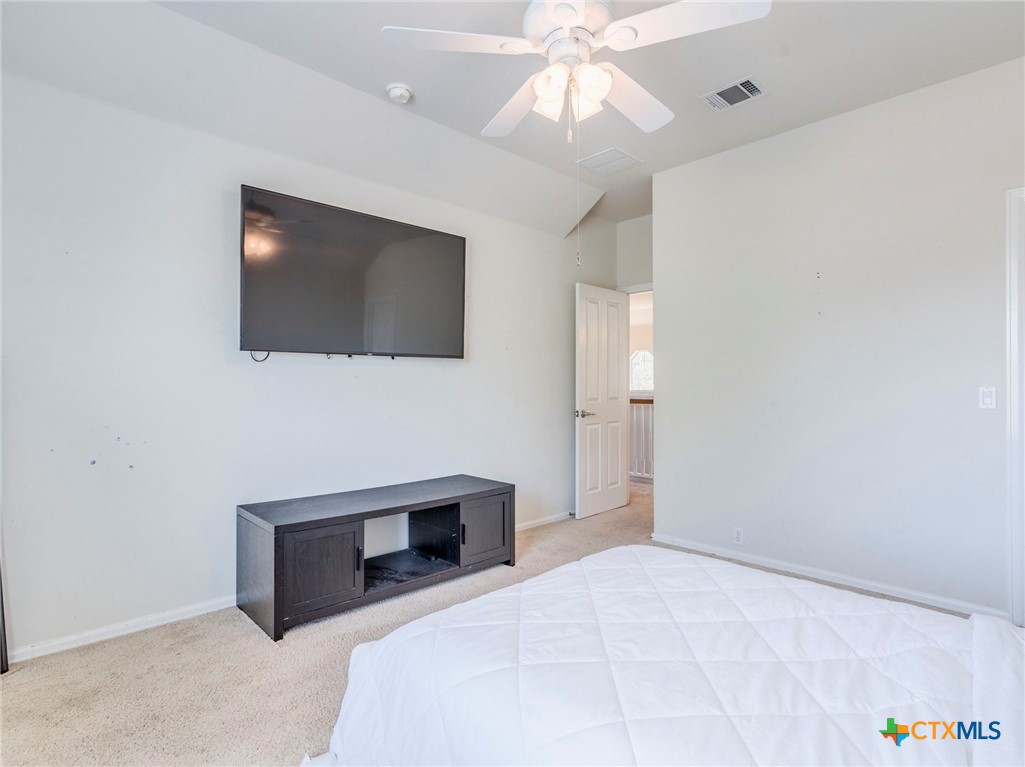 125 Sweet Gum Drive Kyle, TX 78640 - Photo 22 of 31 a bedroom with a bed and a flat screen tv