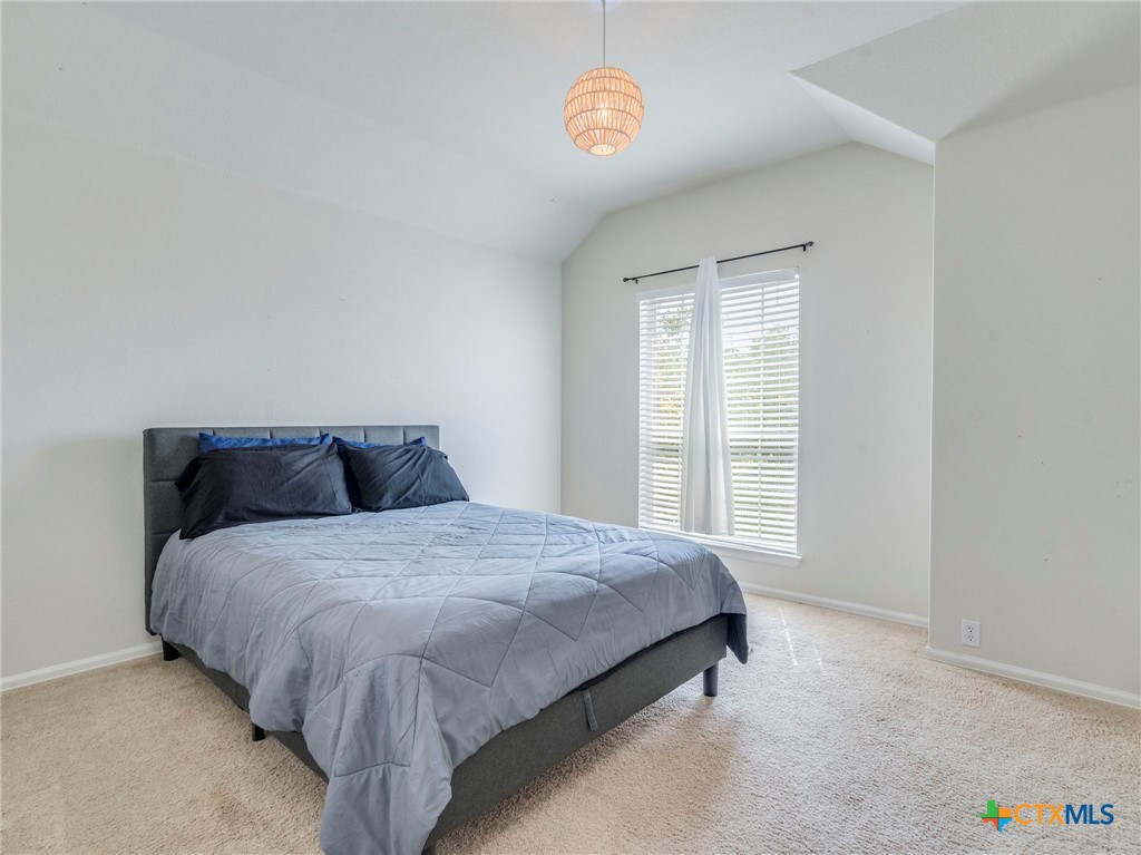 125 Sweet Gum Drive Kyle, TX 78640 - Photo 23 of 31 a spacious bedroom with a bed and a window