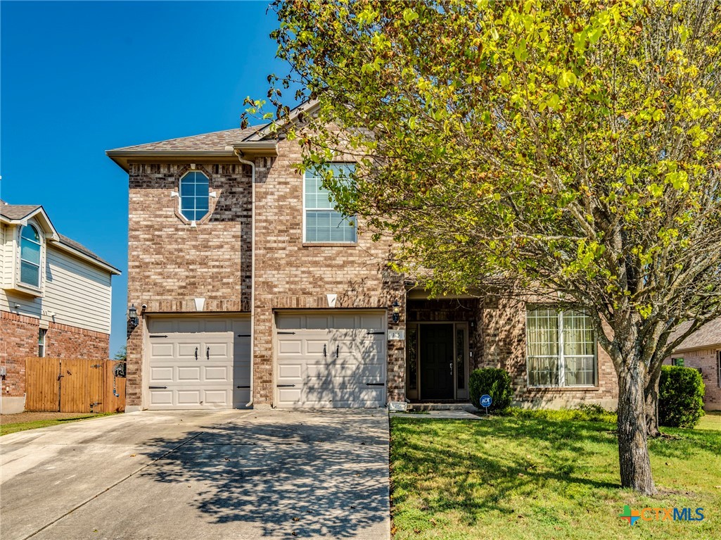 125 Sweet Gum Drive Kyle, TX 78640 - Photo 3 of 31 a front view of a house with a garden and trees