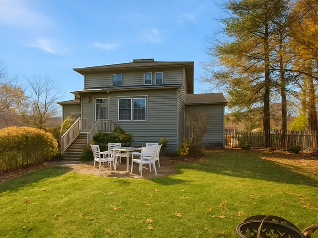 a backyard of a house with table and chairs