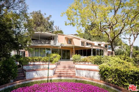 a front view of a house with a yard and tree s