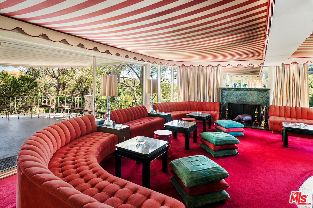 10934 Bellagio Road Los Angeles, CA 90077 - Photo 22 of 52 a living room with furniture a fireplace and a floor to ceiling window