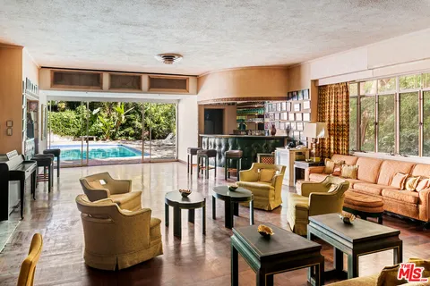 a view of a porch with chairs and potted plants