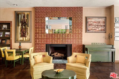 a living room with fireplace furniture and a large window