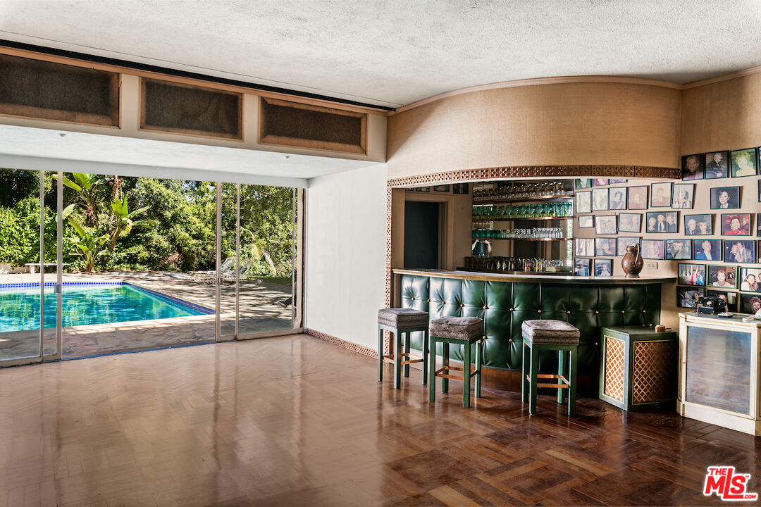 10934 Bellagio Road Los Angeles, CA 90077 - Photo 27 of 52 a view of a porch with chairs and potted plants