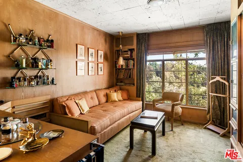 a view of a patio with table and chairs and couches with wooden floor and fence