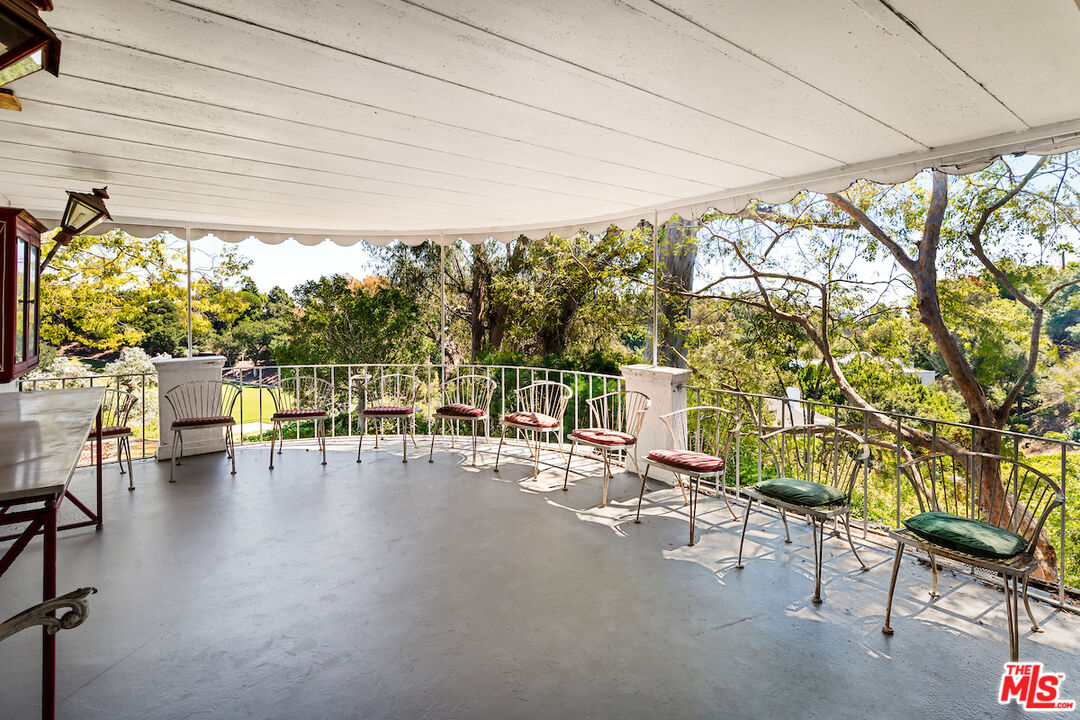 10934 Bellagio Road Los Angeles, CA 90077 - Photo 36 of 52 a view of a patio with table and chairs and couches with wooden floor and fence