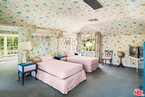 a bedroom with two beds and painting on the wall