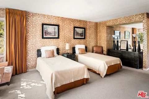 a bed sitting in a bedroom next to a window