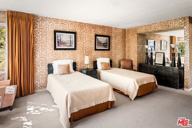 a bed sitting in a bedroom next to a window