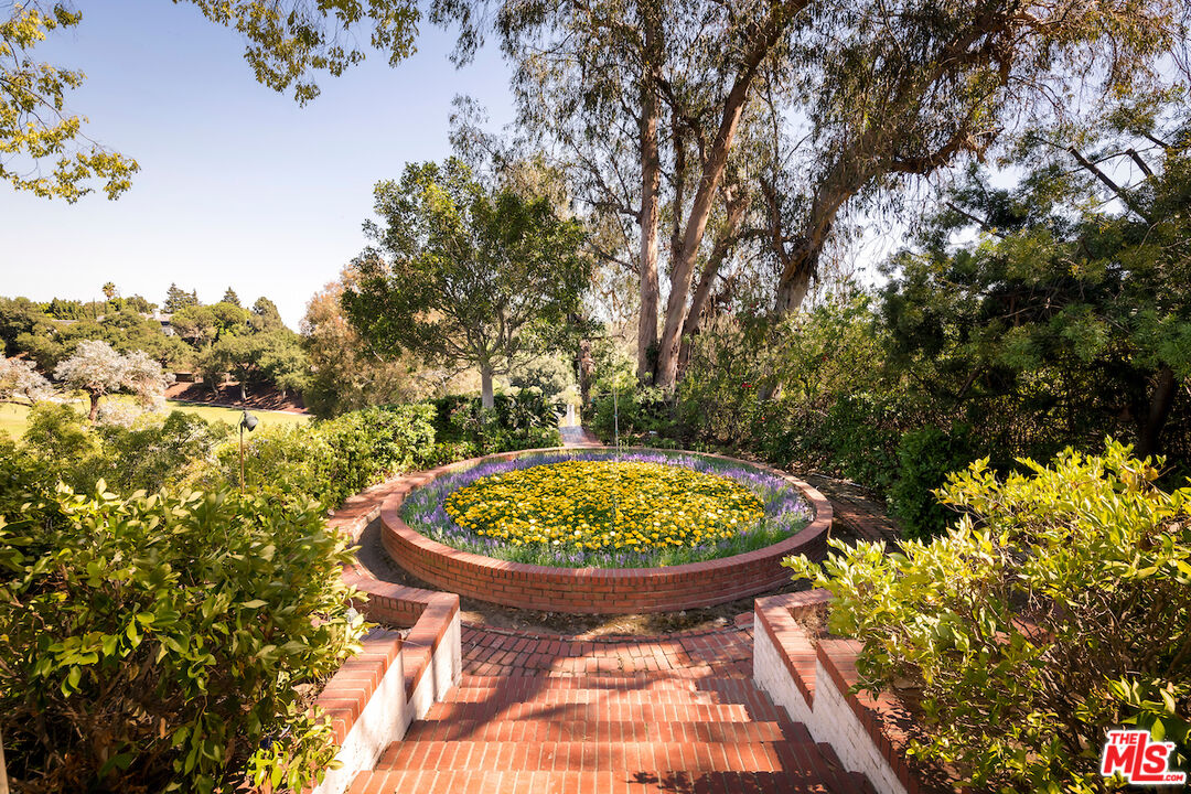 10934 Bellagio Road Los Angeles, CA 90077 - Photo 45 of 52 a view of a swimming pool with a garden