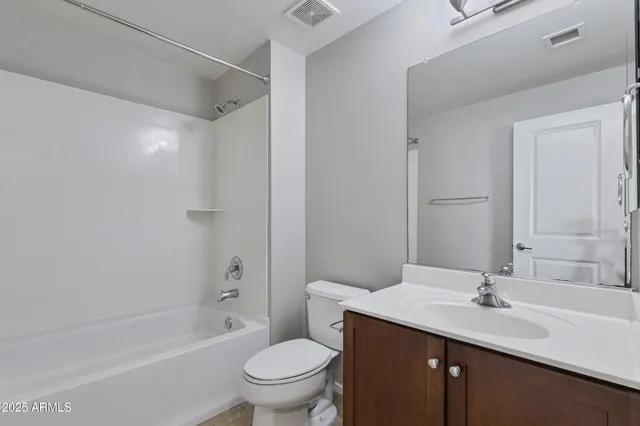 a bathroom with a granite countertop sink a toilet and shower