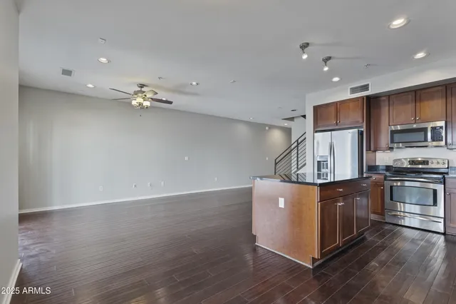a kitchen with kitchen island granite countertop a sink stainless steel appliances and cabinets