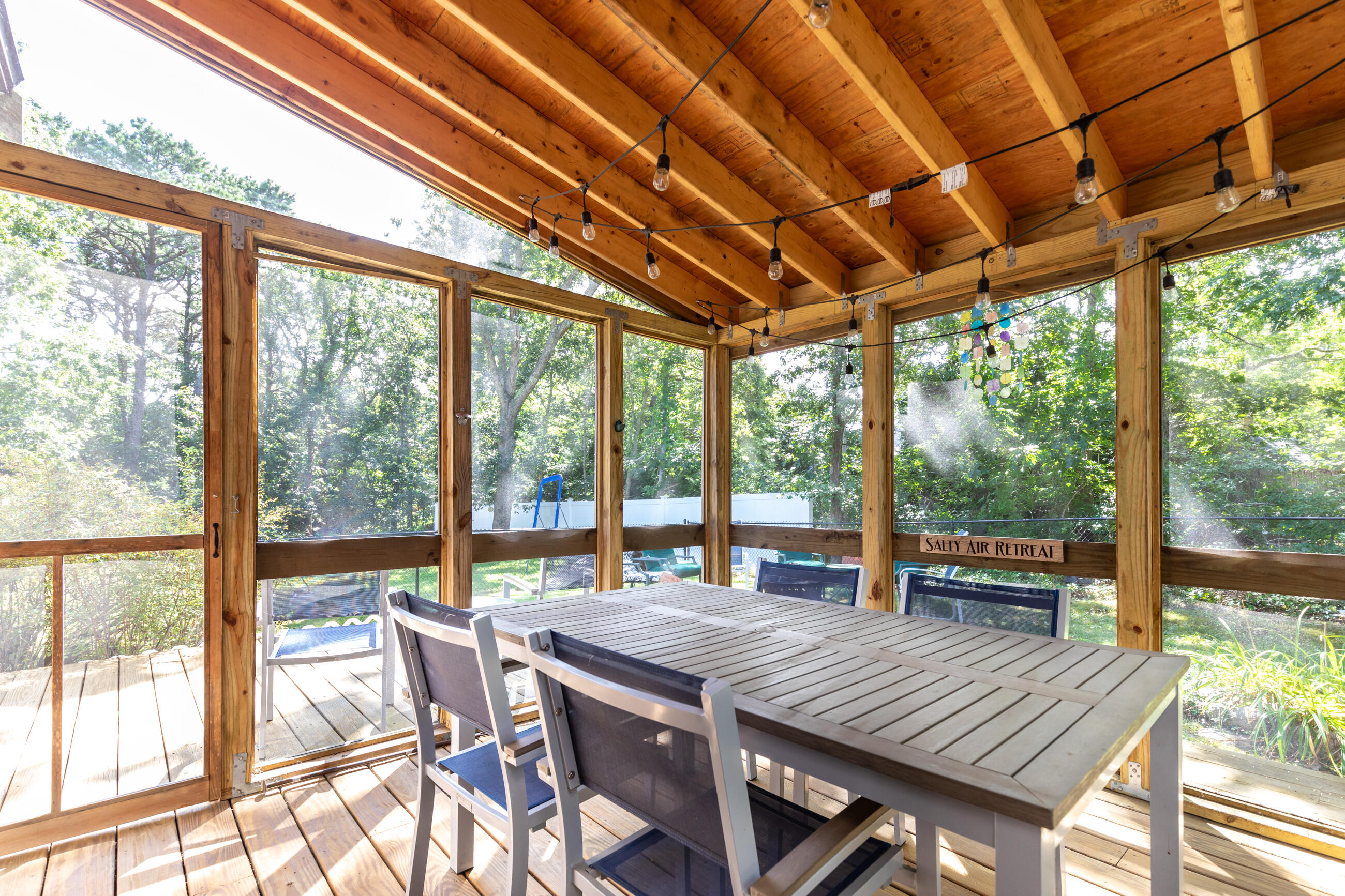 35 Whitney Road Eastham, MA 02642 - Photo 27 of 31 a view of a patio with table and chairs and wooden floor