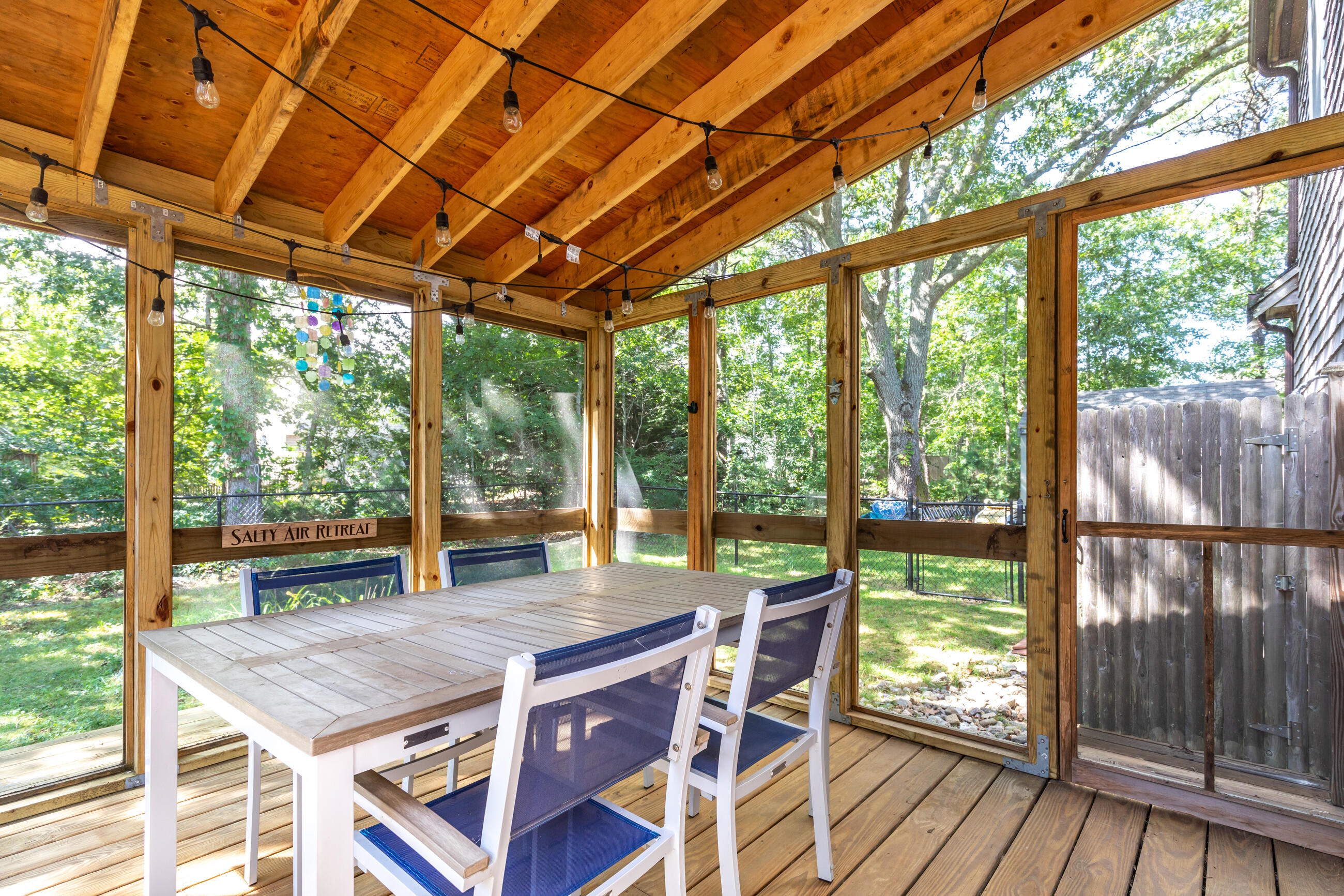 35 Whitney Road Eastham, MA 02642 - Photo 28 of 31 a view of a patio with table and chairs and wooden floor