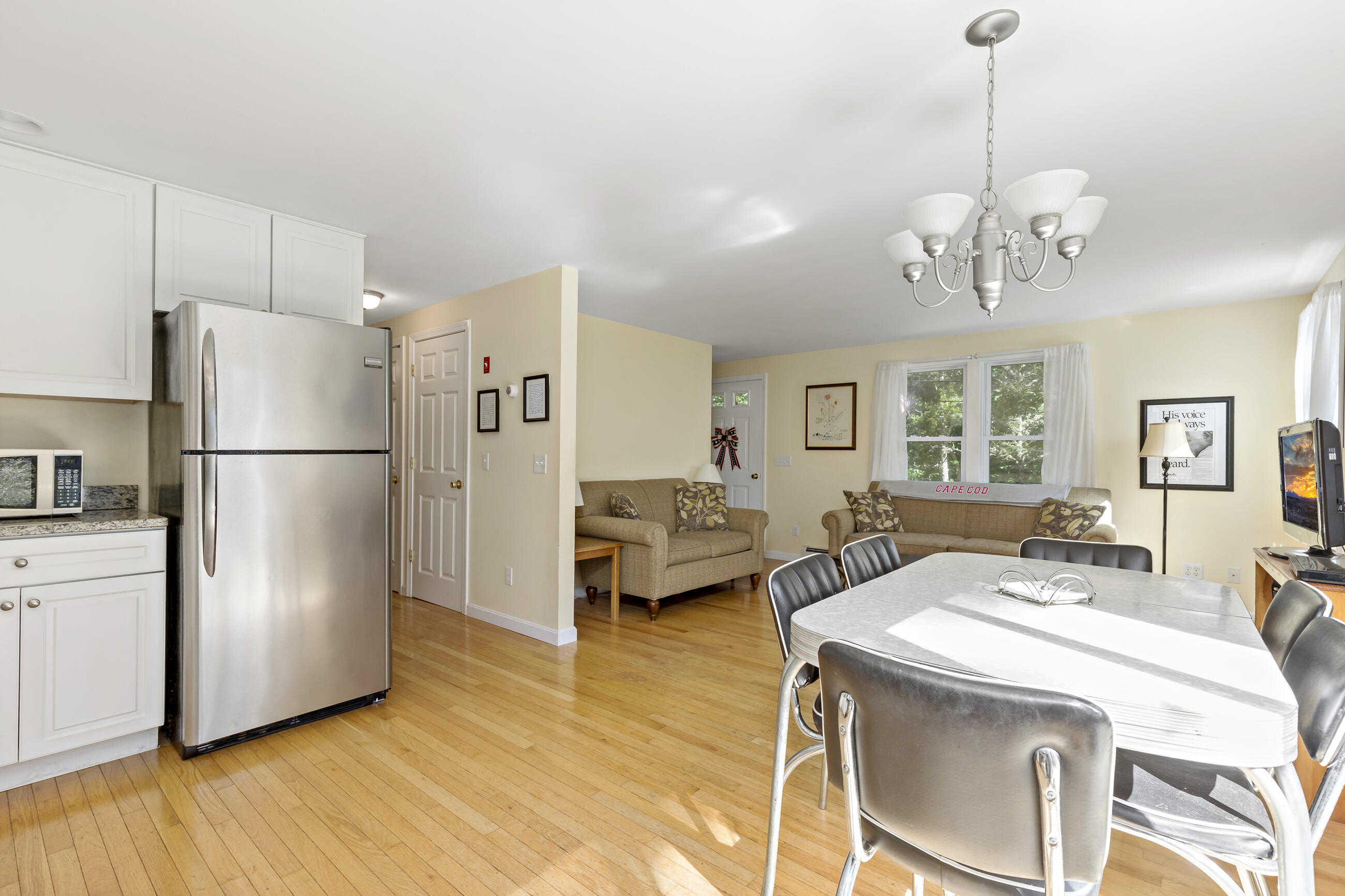 35 Whitney Road Eastham, MA 02642 - Photo 7 of 31 a kitchen with stainless steel appliances a refrigerator a sink dishwasher a oven with white cabinets and wooden floor