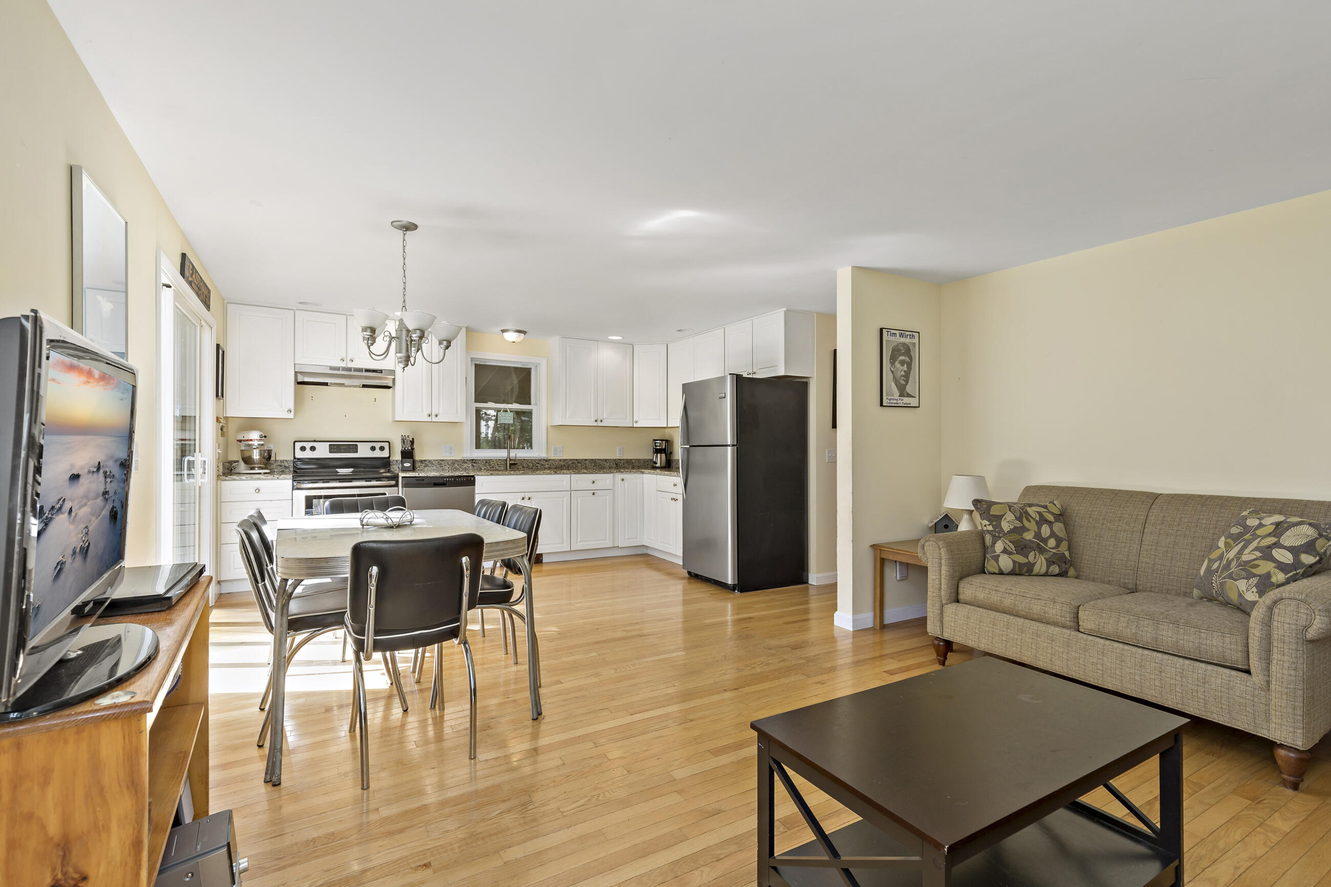 35 Whitney Road Eastham, MA 02642 - Photo 9 of 31 a living room with stainless steel appliances a dining table wooden floor and a kitchen view
