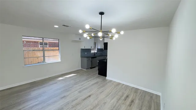 a view of a kitchen with wooden floor and chandelier