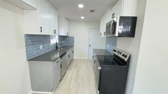 a kitchen with a sink and stainless steel appliances