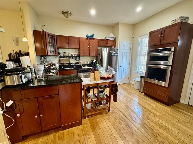 a kitchen with stainless steel appliances wooden floors wooden cabinets and sink