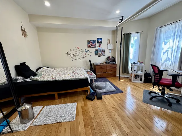 a bedroom with furniture and wooden floor