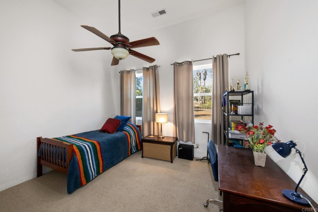 15460 Markar Road Poway, CA 92064 - Photo 22 of 36 a bedroom with a bed a chandelier and a desk