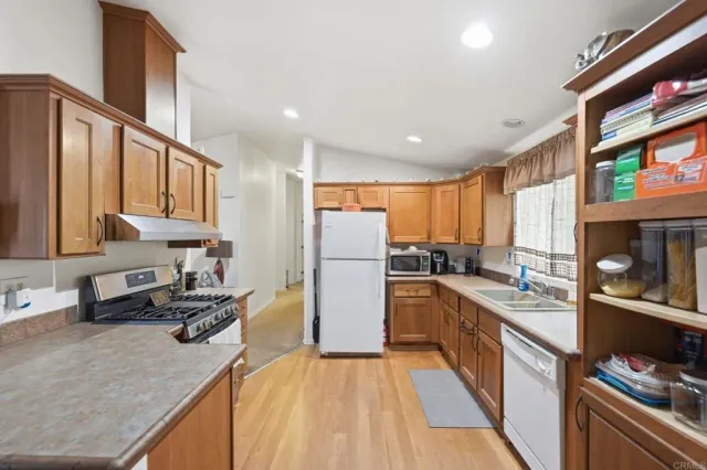 a kitchen with a refrigerator a sink and a stove top oven