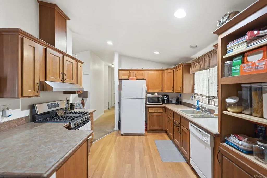 10767 Jamacha Spring Valley, Unit SPC 119 Spring Valley, CA 91978 - Photo 7 of 25 a kitchen with a refrigerator a sink and a stove top oven