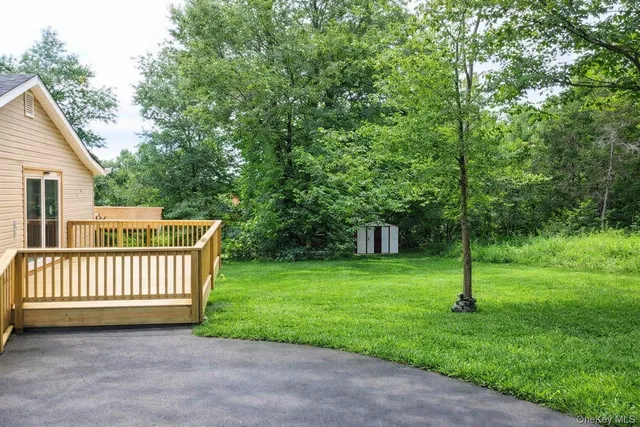 a view of a yard with a deck and a garden