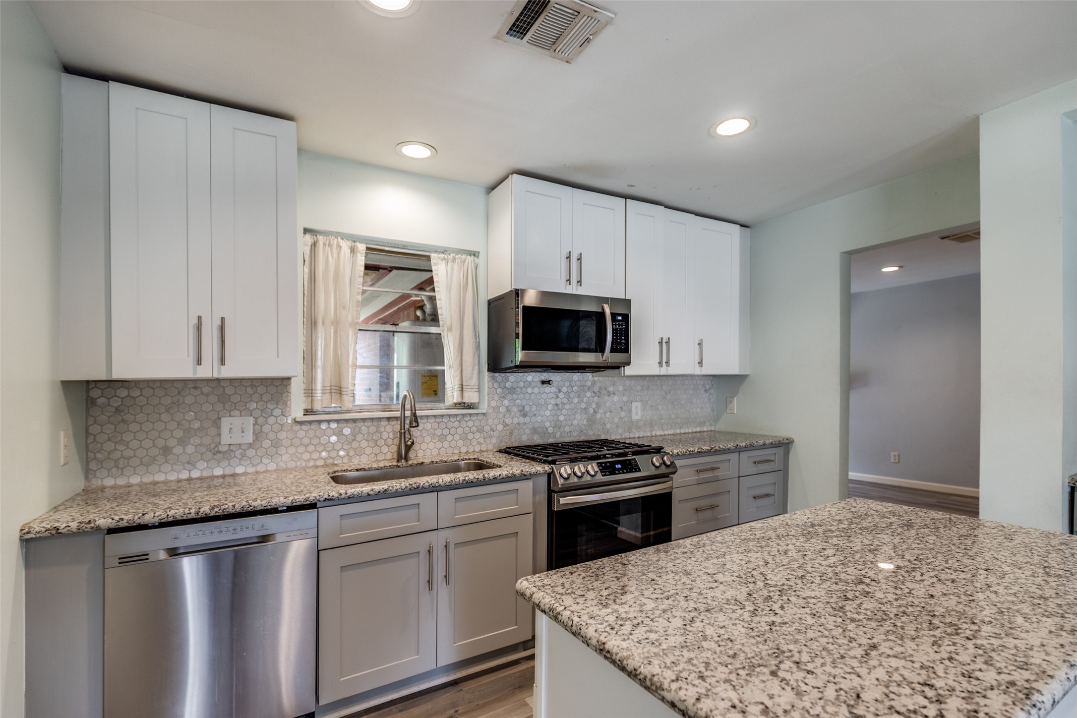 2007 Hewitt Drive Houston, TX 77018 - Photo 6 of 25 a kitchen with stainless steel appliances granite countertop a stove a sink and a microwave