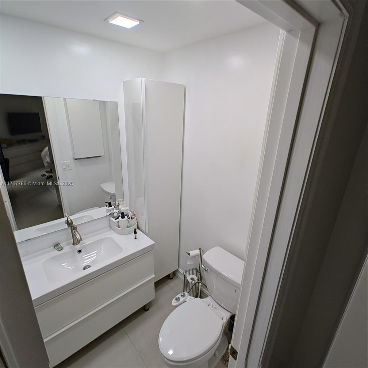 2750 Northeast 183rd Street, Unit 301 Aventura, FL 33160 - Photo 12 of 38 a bathroom with a sink toilet and mirror