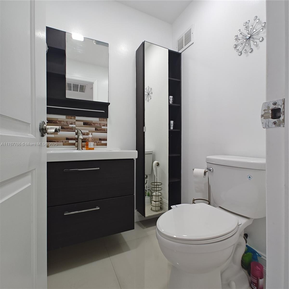 2750 Northeast 183rd Street, Unit 301 Aventura, FL 33160 - Photo 20 of 38 a bathroom with a toilet sink and mirror