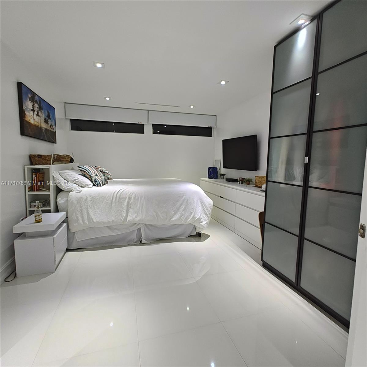 2750 Northeast 183rd Street, Unit 301 Aventura, FL 33160 - Photo 5 of 38 a bedroom with a bed and a flat screen tv