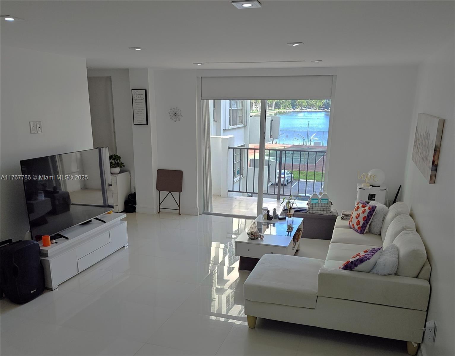 2750 Northeast 183rd Street, Unit 301 Aventura, FL 33160 - Photo 6 of 38 a living room with furniture and a flat screen tv