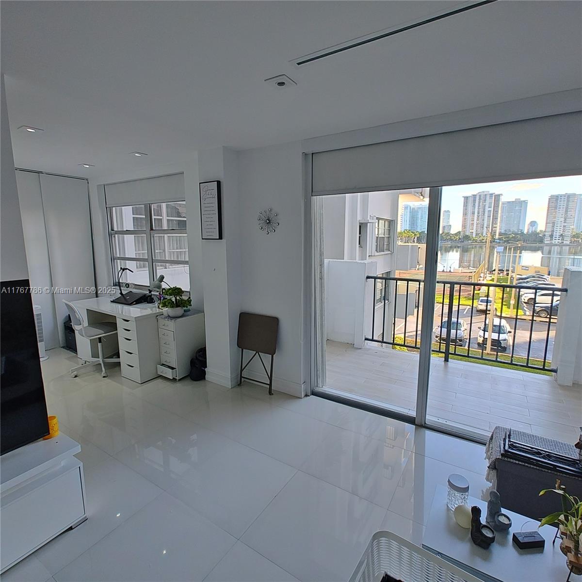 2750 Northeast 183rd Street, Unit 301 Aventura, FL 33160 - Photo 7 of 38 a living room with furniture a flat screen tv and a window