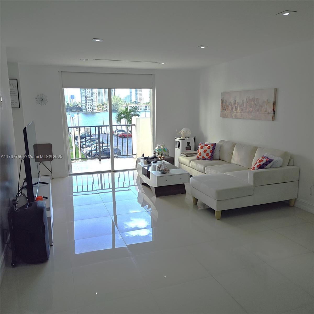 2750 Northeast 183rd Street, Unit 301 Aventura, FL 33160 - Photo 8 of 38 a living room with furniture and a flat screen tv