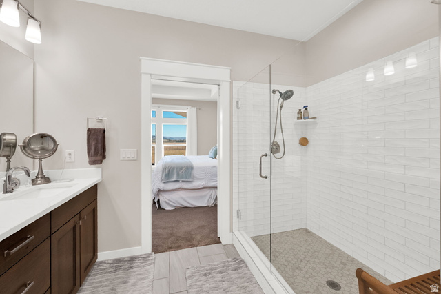 352 East Boulderville Road Oakley, UT 84055 - Photo 22 of 62 Ensuite bathroom with vanity, a shower stall, light tile patterned floors, and light colored carpet